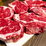 A marbled beef rib eye steak is waiting to be grilled.
